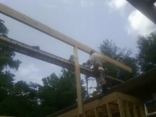 Carpenter setting a ridge beam over a new addition frame — Ice Dam Removal by Roofing Brothers in Hooversville