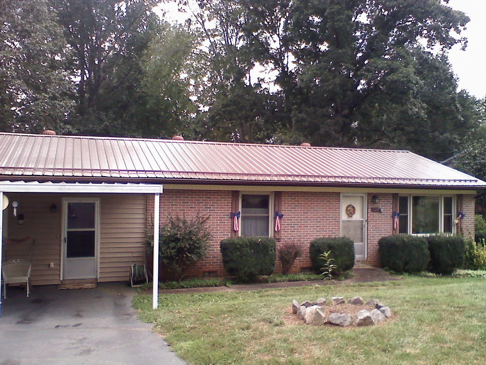 Bronze metal roof and carport on a brick ranch home — Roof Repair work by our crew in Hooversville
